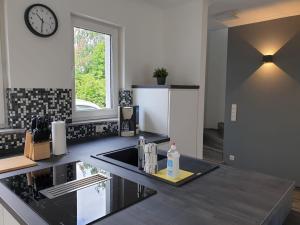 a kitchen with a sink and a clock on the wall at Haus Strandoase Nr 4 in Oldenburg in Holstein