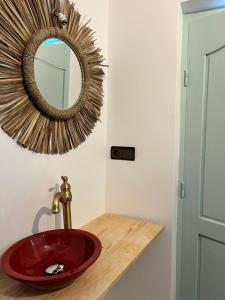 a bathroom with a red sink and a mirror at windora essaouira in Essaouira