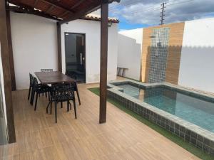 a patio with a table and chairs and a swimming pool at Casa in Petrolina