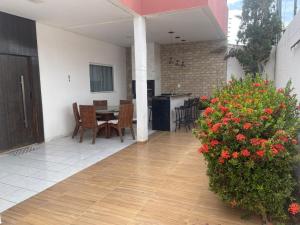 a patio with a table and chairs and flowers at Casa in Petrolina