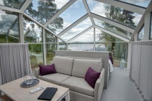 a glass house with a couch and a table at Lunar Igloos - Lumi in Karkku