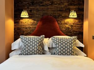 a bed with a red headboard and two pillows at East Beach Guest House in Littlehampton