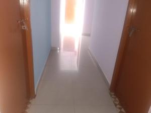 a hallway with a door and a room with white walls at coastal charm in Chennai