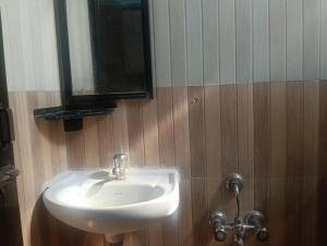 a bathroom with a white sink and a mirror at coastal charm in Chennai