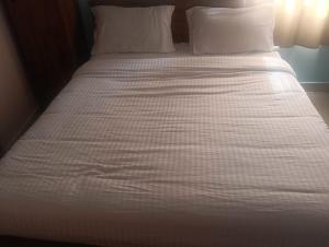 a white bed with white sheets and pillows at coastal charm in Chennai