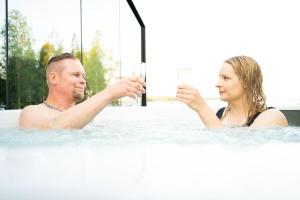 a man and woman in the bathtub with champagne at Lunar Igloos - Lumi in Karkku
