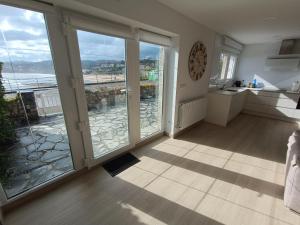 a kitchen with sliding glass doors and a view of the ocean at Casa del Muelle COMILLAS in Comillas