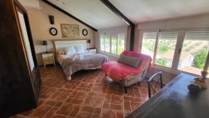 a bedroom with a bed and a chair and windows at Villa Alfaguara-Holiday Home Granada & Sierra Nevada in Granada +84 photos