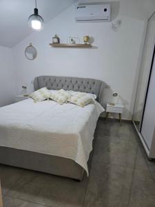 ein Bett in einem weißen Zimmer mit Bettrock in der Unterkunft הסוויטה בטיילת in Aschdod