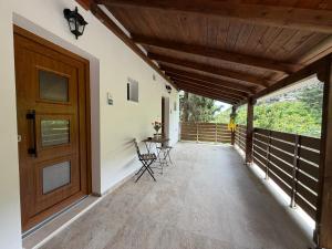a porch with a wooden door and a table and chairs at Avra Rooms in Limnionas