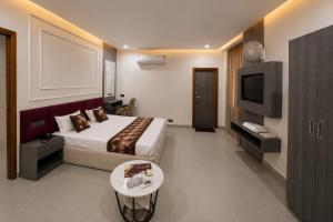 a hotel room with a bed and a tv at Hotel Golden Plaza in Amritsar