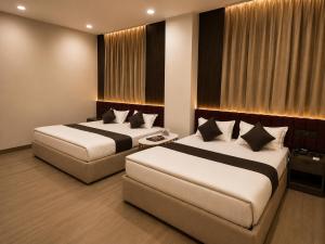 two beds in a hotel room with two beds sidx sidx sidx at Hotel Golden Plaza in Amritsar