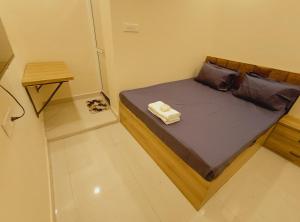 a small bed in a small room with a wooden frame at Hotel Mahakal Ujjain Prime in Ujjain