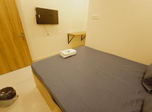 a small room with a bed with a tv on the wall at Hotel Mahakal Ujjain Prime in Ujjain