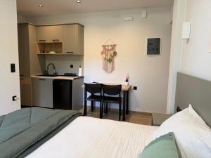 a bedroom with a bed and a table and a kitchen at Avra Rooms in Limnionas +18 photos
