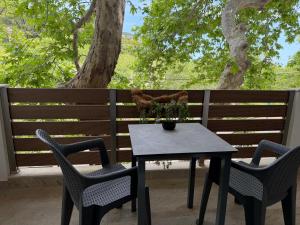 a table and chairs on a patio with a fence at Avra Rooms in Limnionas