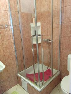 a shower with a red towel in a bathroom at Apartman Mare in Kaštela