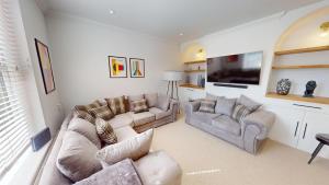 a living room with two couches and a tv at Sheringham Luxury, Cinema, Hot Tub & Beach in Sheringham