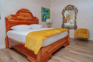 a bedroom with a wooden bed with a large mirror at Royale Jazz Hotel in Kingston +7 photos
