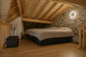 a bedroom with a bed and a stone wall at Casa Saudade Vila Real North in Vila Real
