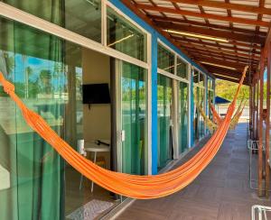 an orange hammock hanging inside of a building at Flats Praia de Gravatá in São José da Coroa Grande