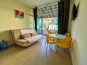 a living room with a couch and a table and chairs at Flats Praia de Gravatá in São José da Coroa Grande