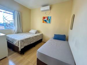 a bedroom with two beds and a window at Flats Praia de Gravatá in São José da Coroa Grande +21 photos