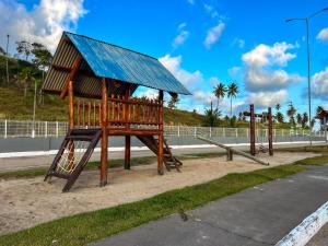 a playground with a small hut on the side of a road at Flats Praia de Gravatá in São José da Coroa Grande