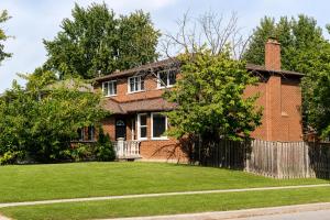 a brick house with a fence in front of a yard at Lux 5BR Spacious Home Near Yonge St in Newmarket