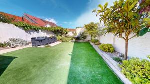 a garden with a green lawn and benches at Sheringham Luxury, Cinema, Hot Tub & Beach in Sheringham +26 photos
