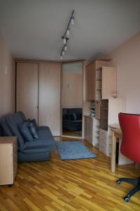 a living room with a blue couch and a kitchen at Nida Center Studio Apartment in Neringa +3 photos