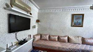 a living room with a couch and a flat screen tv at Melilla Gate House in Nador