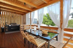 a dining room with a table and chairs on a deck at Strandhaus Ahoi 17, Terrasse mit Meerblick, Privatstrand, 2 Badezimmer in Drage