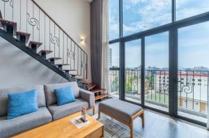 a living room with a couch and a large window at Luxury Duplex & Apartment Pentstudio - Tay Ho Hanoi in Hanoi