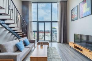 a living room with a couch and a staircase at Luxury Duplex & Apartment Pentstudio - Tay Ho Hanoi in Hanoi