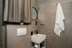 a bathroom with a sink and a shower curtain at Strandhaus Ahoi 17, Terrasse mit Meerblick, Privatstrand, 2 Badezimmer in Drage +29 photos