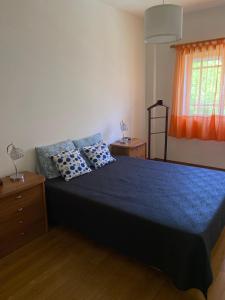 a bedroom with a blue bed with two blue pillows at Caparica Sol&Mar Apartment in Costa da Caparica