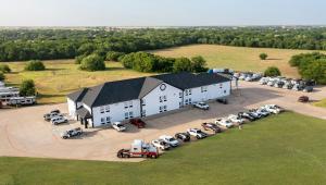an aerial view of a large white building with a parking lot at Atria Hotel and RV McGregor in McGregor