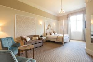 ein Wohnzimmer mit einem Bett und einer Couch in der Unterkunft Wroxall Abbey Hotel & Estate in Wroxall