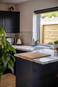 a kitchen with a wooden cutting board on a counter at 11 Dune View in Braunton