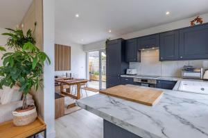 a kitchen with black cabinets and a marble counter top at 11 Dune View in Braunton
