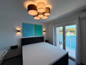 a dining room with a white table and a ceiling light at Apartman Blaga in Povlja