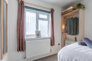 a bedroom with a bed and a window at 11 Dune View in Braunton