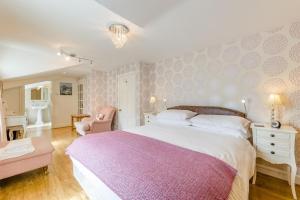 a bedroom with a large bed with a pink blanket at 3 Bed in Aberaeron oc-86578 in Aberaeron