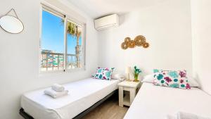 two beds in a room with a window at Mar, terraza y parking in Santa Pola