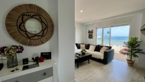a living room with a couch and a mirror at Mar, terraza y parking in Santa Pola +34 photos