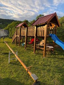 a group of wooden playground equipment in a field at Apartman za odmor Plivska Jezera in Jajce