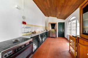 a kitchen with white walls and a wooden ceiling at Quinta do Outeiro by Soulplaces in Almargem