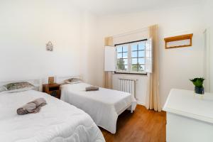 two beds in a white room with a window at Quinta do Outeiro by Soulplaces in Almargem +34 photos