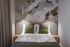 a bedroom with a bed with birds on the wall at Marina Piaski Apartamenty in Piaski